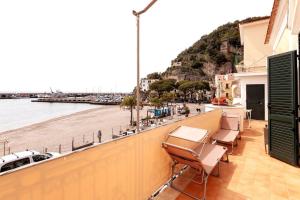 a balcony with chairs and a view of a beach at Casa del pozzo sulla spiaggia in Cetara