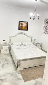 - une chambre blanche avec un lit et 2 tables de chevet dans l'établissement Tetouan Relax Apartement, à Tetouan