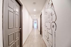 a corridor with a door and a hallway with white walls at Townhouse Akota Mujmahuda Road - Managed by Company in Vadodara