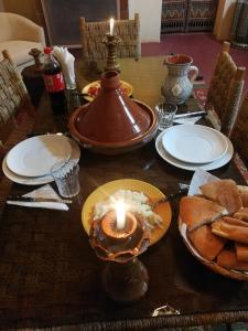 a table with a candle and bread on it at Chez Kossai Atlas Farm in Chtawna