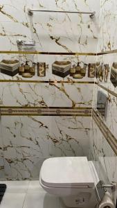 aseo blanco en un baño con paredes de mármol en Hotel Biarritz, en Tánger