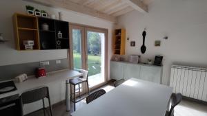 une cuisine avec une table et des chaises blanches ainsi qu'une fenêtre dans l'établissement Memento, à Ossi