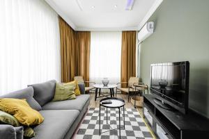 a living room with a couch and a tv at Flat with Balcony 5 min to Konyaalti Beach in Antalya