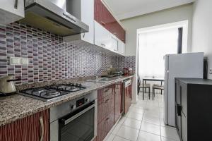 y cocina con fogones y nevera. en Flat with Balcony 5 min to Konyaalti Beach, en Antalya