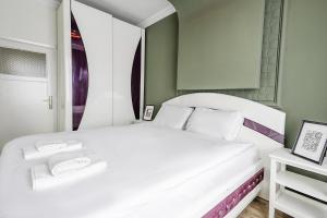 a white bed in a room with a mirror at Flat with Balcony 5 min to Konyaalti Beach in Antalya