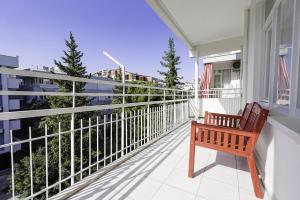 una panchina di legno seduta sul balcone di una casa di Flat with Balcony 5 min to Konyaalti Beach a Antalya (Adalia)