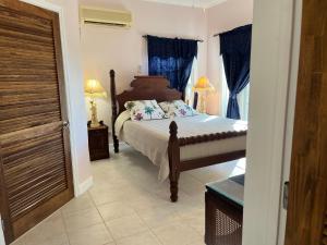 a bedroom with a bed with blue curtains at Royal Palm Villas 
