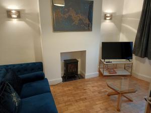 a living room with a blue couch and a fireplace at Phoenix House 4 BED ideal contractor & those working away in Lincolnshire