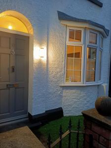 una casa azul con puerta y ventana en Phoenix House 4 BED ideal contractor & those working away, en Lincolnshire