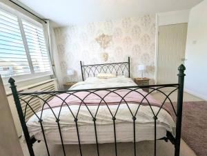 ein Schlafzimmer mit einem schwarzen Bett und einer rosa Decke in der Unterkunft Spacious lovely 3 Bed House in Keyworth Nottingham suit CONTRACTORS OR FAMILY 