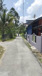 an empty road in front of a building at Raptronics Homestay Kampung in Kota Bharu
