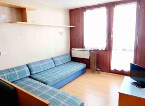 een woonkamer met een blauwe bank in een kamer bij Condominio La Grand'Ourse - Cervinia in Breuil-Cervinia