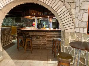 un bar en un restaurante con taburetes y mostrador en Kappsfarm Guesthouse, en Voigtland