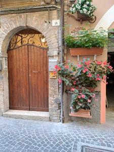 an entrance to a building with a wooden door and flowers at B&B Monolocale Piazza Dante in Teramo