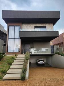 une maison avec une voiture garée devant elle dans l'établissement Mansão Quinta dos Ventos, à Ribeirão Preto