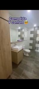 a bathroom with a toilet and a sink and a mirror at Apartamento sabaneta in Sabaneta