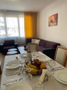 a dining table with a plate of fruit on it at Grand Monastery Private Apartments in Pamporovo