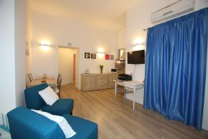 a living room with a blue couch and a desk with a television at B&B Teatro in Palermo