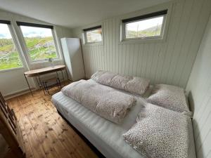 a bedroom with two beds and a table and windows at Idyllic and peaceful Family Home in Tromsø