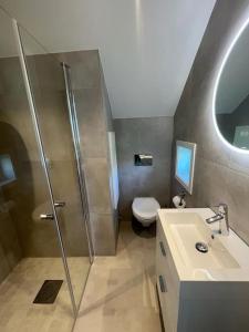 a bathroom with a shower and a toilet and a sink at Idyllic and peaceful Family Home in Tromsø