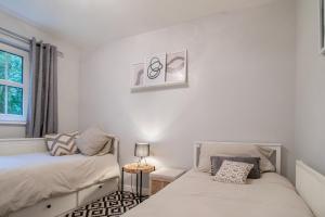 Un dormitorio con dos camas y una ventana. en Garden View Nook-2 bed apartment, en High Blantyre