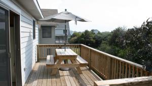 a wooden deck with a picnic table and an umbrella at Semi-Oceanfront, Close to Beach, Dogs Welcome, SA8, Berry in Sanderling