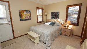 a bedroom with a bed and a table and windows at Semi-Oceanfront, Close to Beach, Dogs Welcome, SA8, Berry in Sanderling