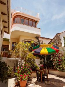 a house with an umbrella and chairs and flowers at Bella Vista El Tronco in Sucre