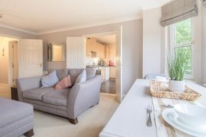 una sala de estar con un sofá y una mesa en Garden View Nook-2 bed apartment, en High Blantyre