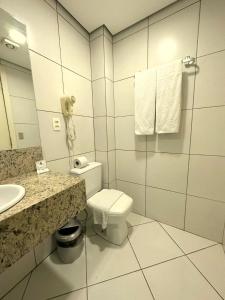 La salle de bains est pourvue de toilettes, d'un lavabo et d'un miroir. dans l'établissement Umbu Hotel Porto Alegre - Centro Histórico - Prox Aeroporto 15min, à Porto Alegre