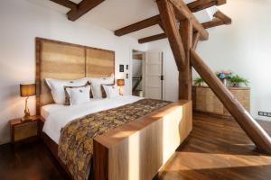 a bedroom with a large bed with a wooden headboard at SCHLOSSRESIDENZ - Boutique Apartments & Hotel Suiten in Garbsen