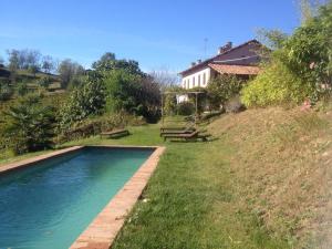 a swimming pool in the grass next to a house at Casa Isabella in Vaglio Serra