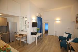 a kitchen and a living room with a table and chairs at B&B Teatro in Palermo