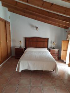um quarto com uma cama grande e duas mesas de cabeceira em Casa Rosa em Alcalalí