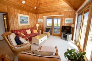 un salon avec un canapé et une télévision dans l'établissement Semi-Oceanfront, secluded Beach Cottage, Close to Beach! SA210, Farmer, à Sanderling