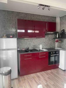 a kitchen with red cabinets and a black stove at T2 Saint Laurent in Orléans