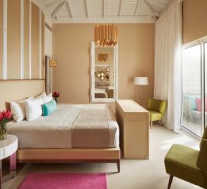 una camera con letto, sedia e specchio di Azul Beach Resort Negril, Gourmet All Inclusive by Karisma a Negril Altre 37 foto