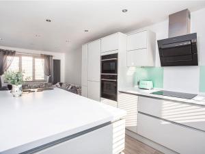 a kitchen with white cabinets and a white counter top at Holgate Lodge in York +4 photos