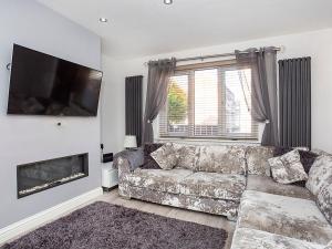 uma sala de estar com um sofá e uma televisão de ecrã plano em Holgate Lodge em York