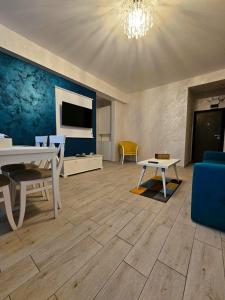 een woonkamer met een bank en een tv bij Sunrise Residence in Mamaia Nord – Năvodari