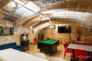 a room with a ping pong table and a tv at A modern Maltese townhouse in Siggiewi in Siġġiewi