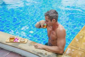 a man sitting in a swimming pool eating a drink at Rendezvous Classic House in Chiang Mai +148 photos