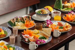 a table with many plates of food on it at Rendezvous Classic House in Chiang Mai