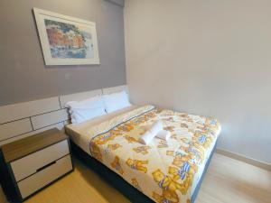 a bedroom with a bed with a yellow comforter at Windmill Pemium 2-bedrooms at Genting High Floor Free WiFi in Genting Highlands