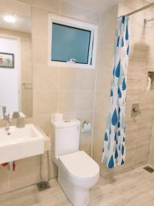 a bathroom with a toilet and a sink and a window at Windmill Pemium 2-bedrooms at Genting High Floor Free WiFi in Genting Highlands