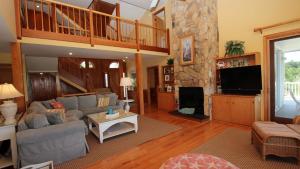 a living room with a couch and a tv at Oceanside, Priv Pool, poolside grilling, sun decks, SEA6, Morningstar in Duck