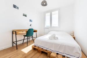格勒諾布爾的住宿－4 personnes - 2 chambres -fibre - balcon - confort，一间卧室配有一张床、一张桌子和一把椅子