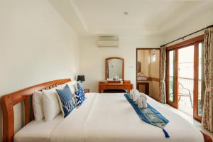 a bedroom with a large bed with a mirror at Rendezvous Classic House in Chiang Mai
