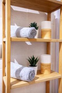 a wooden shelf with towels and plants on it at Piso con dos dormitorios frente a Plaza Mayor in Madrid
