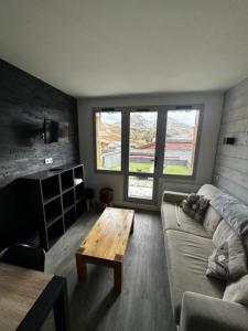 a living room with a couch and a coffee table at Résidence Andromède in Belle Plagne